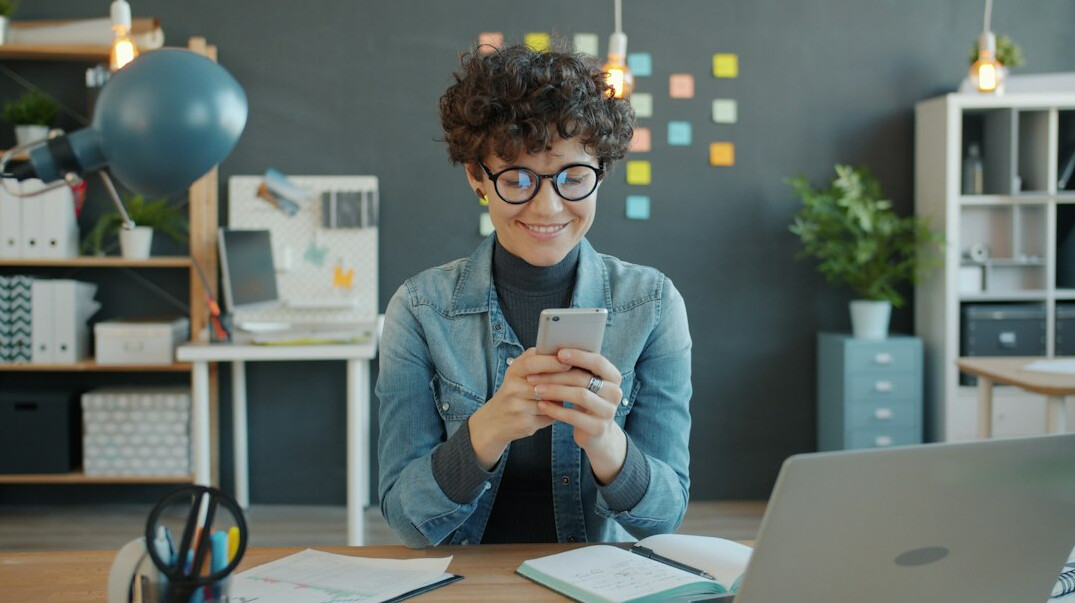 person using phone at desk